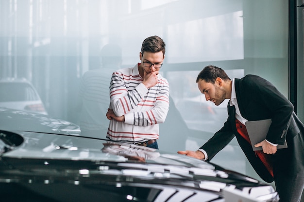 Vendedor en una sala de exposición de coches vendiendo un coche.