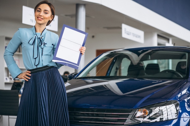 Vendedor de sexo femenino en una sala de exposición del coche