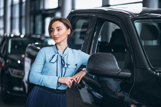 Vendedor de sexo femenino en una sala de exposición del coche