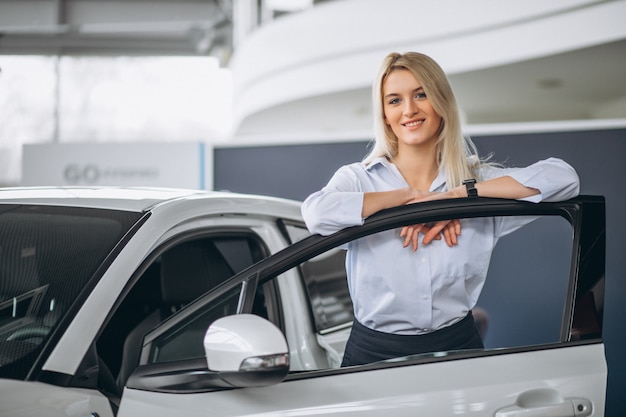 Vendedor de sexo femenino en una sala de exposición del coche