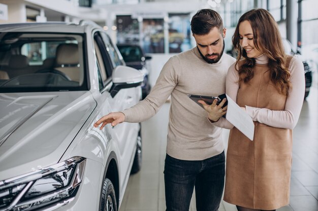 Vendedora hablando con el cliente en un salón de autos