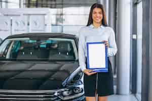 Foto gratuita vendedora en una sala de exposición de coches.