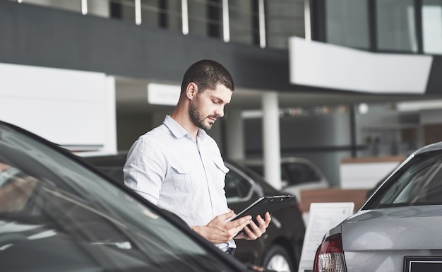 Vendedores jóvenes con una carpeta para vender un coche nuevo.