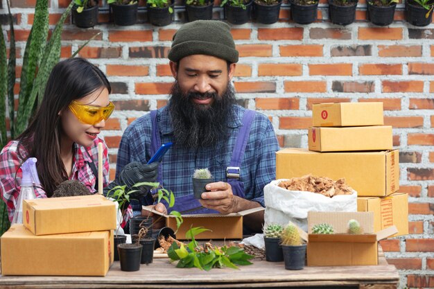 Venta de plantas en línea; parejas felices tomando fotos de plantas por teléfono móvil