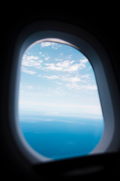 Ventana de avión con cielo y mar lanscape