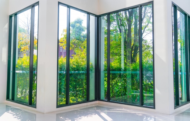 ventana de cristal con vistas a jardín verde.