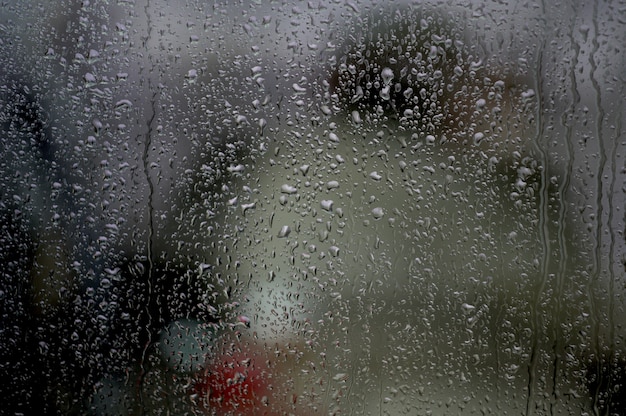 Ventana con gotas de lluvia debajo de las luces