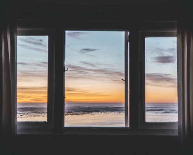 Ventana de tres paneles con una hermosa vista del atardecer afuera