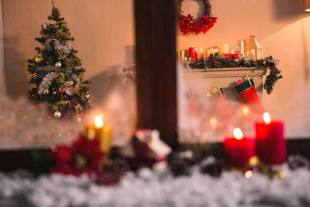 Ventana con velas y nieve y una escena navideña de fondo