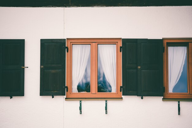 Foto gratuita ventana de vidrio con marco de madera y una cortina blanca en el interior.