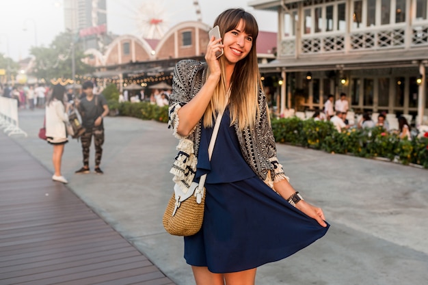 Verano positivo retrato de mujer alegre en traje elegante hablando por teléfono móvil y sonriendo en Riverfront en Bangkok