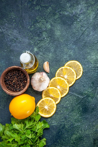 Verdes de botella de aceite de rodajas de limón vista superior en la mesa de la cocina