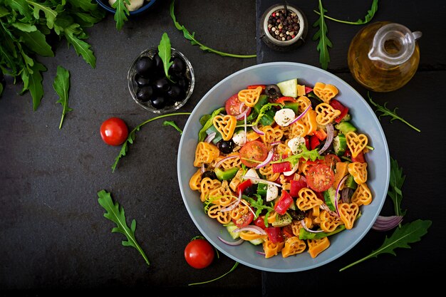 verduras con aceitunas y tomates en superficie oscura