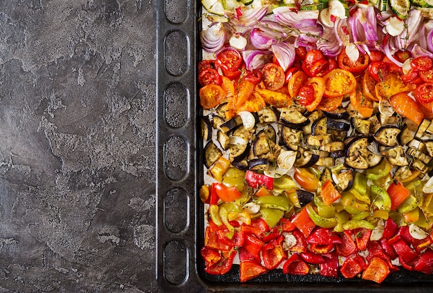 Verduras al horno en una bandeja para hornear. Berenjenas, calabacines, tomates, pimentón y cebolla. Vista superior