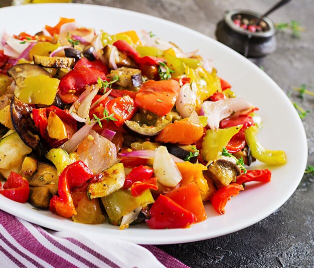 Verduras al horno en un plato blanco. Berenjenas, calabacines, tomates, pimentón y cebolla.