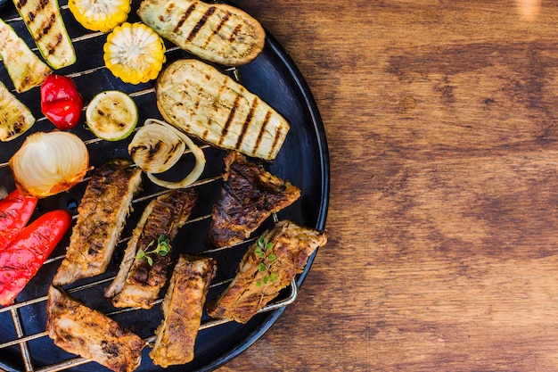 Foto gratuita verduras y carnes a la brasa en parrilla sobre mesa