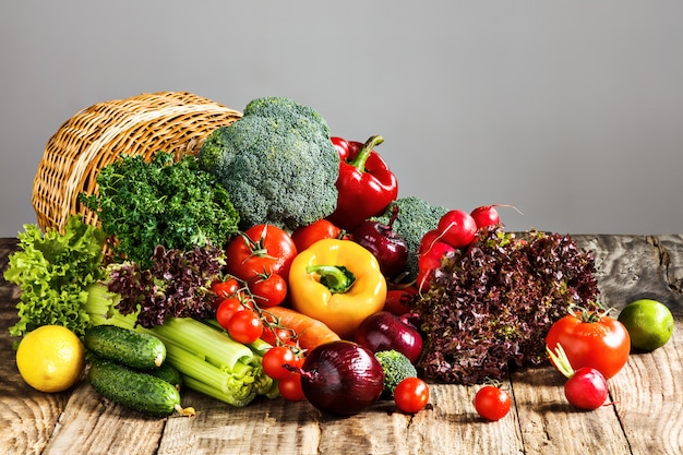 Las verduras de una cesta en la mesa de madera