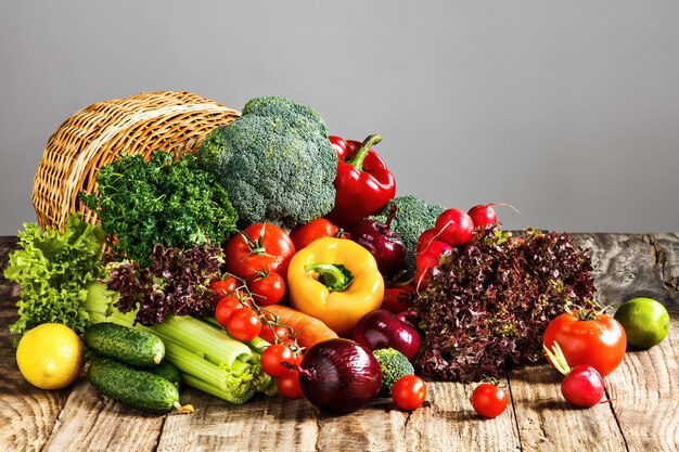 Las verduras de una cesta en la mesa de madera