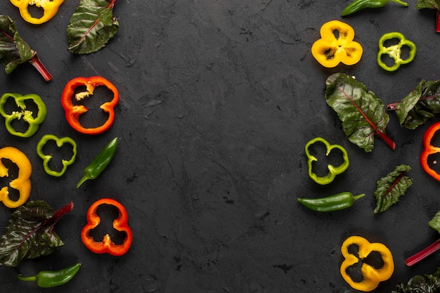 Verduras coloreadas frescas maduras y en rodajas en el escritorio oscuro