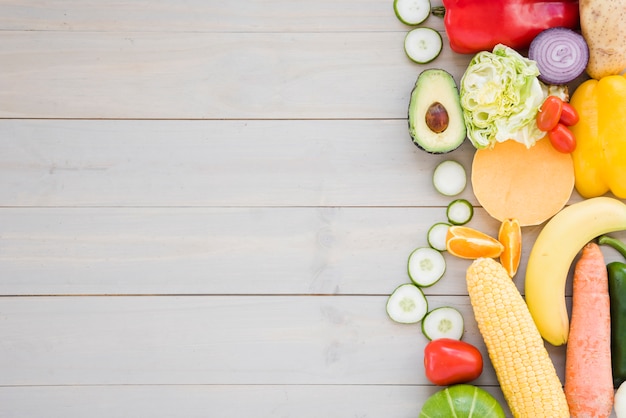 Verduras coloridas sobre fondo de escritorio de madera