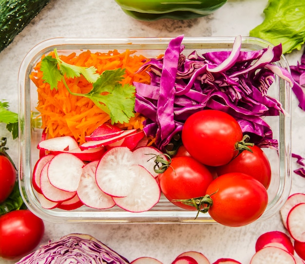Verduras e ingredientes para ensalada en envase.