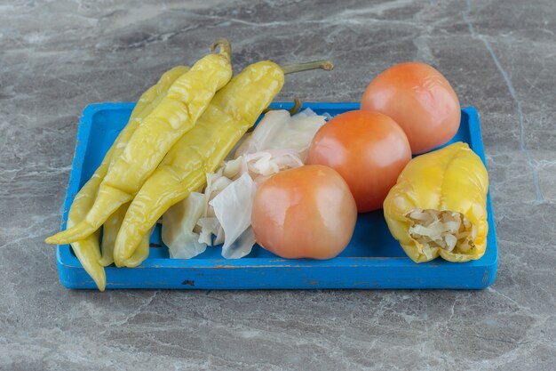 Verduras encurtidas caseras en placa de madera