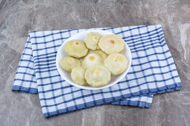 Verduras encurtidas caseras en un tazón blanco.