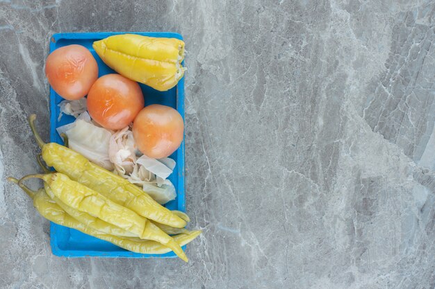 Verduras enlatadas en placa de madera azul. Pepinillo casero.