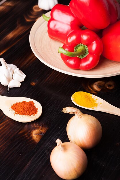 Verduras y especias en polvo sobre tabla de madera quemada