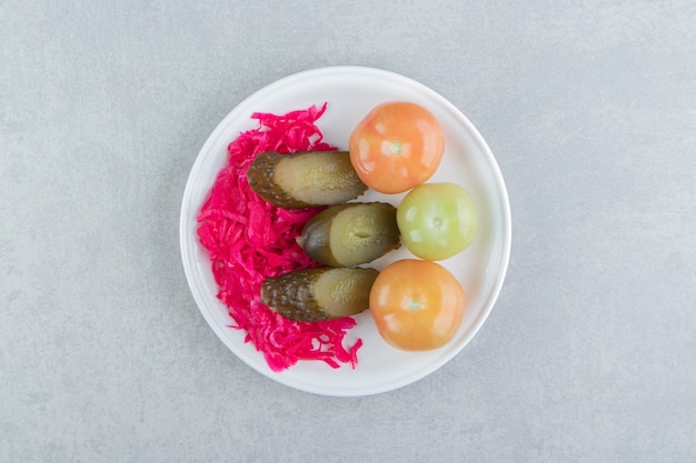 Verduras fermentadas y chucrut en plato blanco.