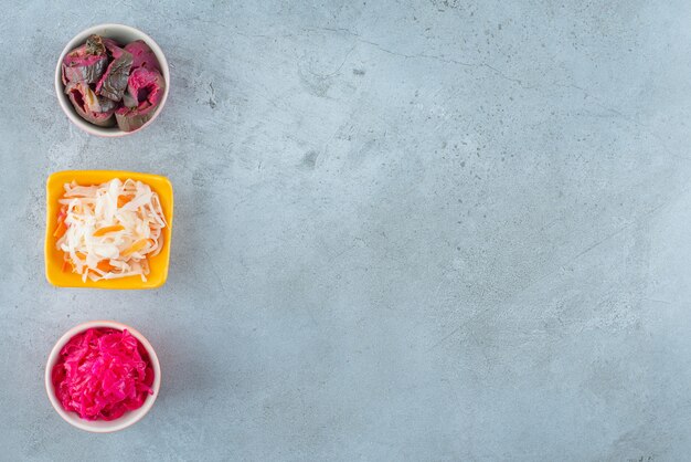 Verduras fermentadas en un tazón, sobre la mesa de mármol.