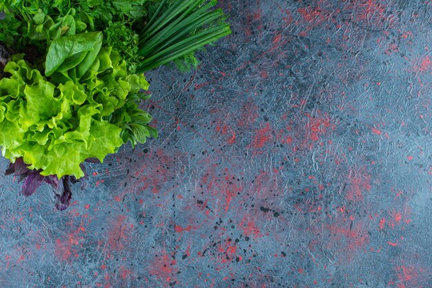 Verduras frescas en una caja, sobre el fondo de mármol.