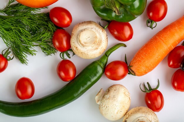 Verduras frescas de colores sobre fondo blanco.