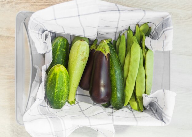 Verduras frescas cosechadas en el recipiente con servilleta.