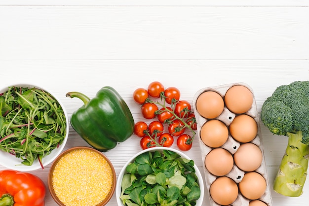 Foto gratuita verduras frescas y huevos en tablero de tablón blanco