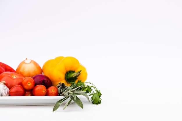 Verduras frescas orgánicas en bandeja aislado sobre fondo blanco.