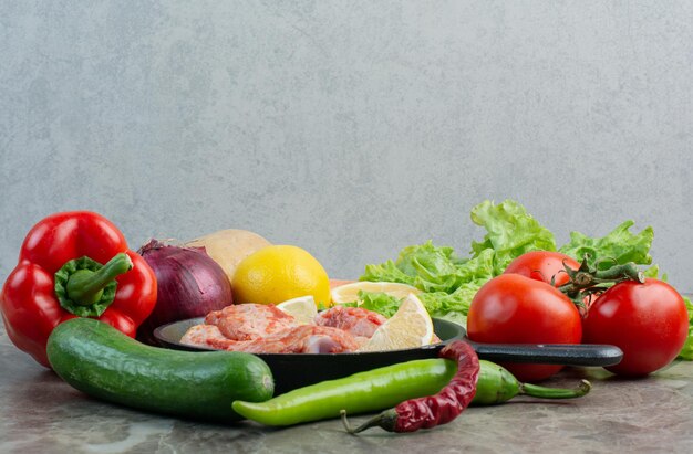 Verduras frescas con pollo crudo sobre fondo de mármol. Foto de alta calidad