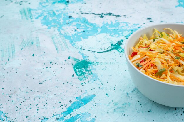 Verduras frescas en rodajas Ensalada de piezas largas y delgadas dentro de la placa redonda en azul