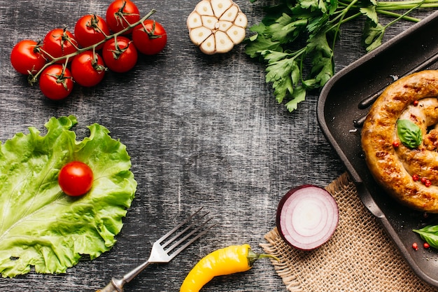 Verduras frescas y salchichas de caracol a la parrilla dispuestas en un marco circular