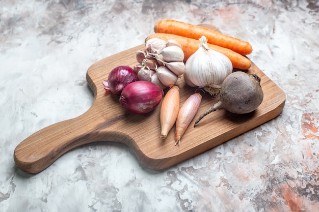 Verduras frescas de vista frontal con ajos en el cuadro blanco