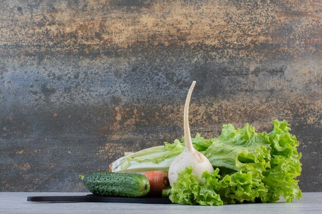 Verduras frescas y zanahorias en tablero negro. Foto de alta calidad