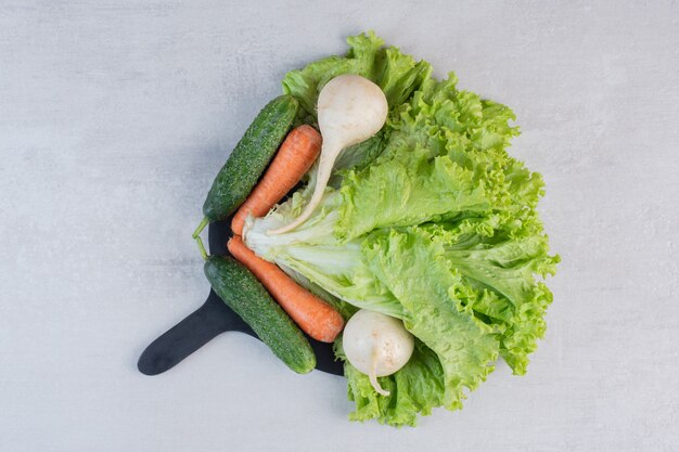 Verduras frescas y zanahorias en tablero negro. Foto de alta calidad