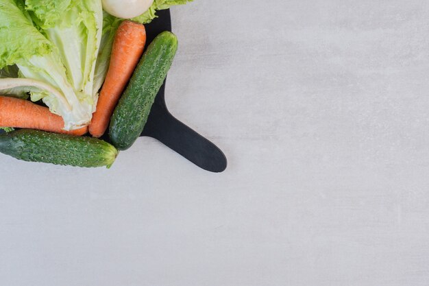 Verduras frescas y zanahorias en tablero negro. Foto de alta calidad