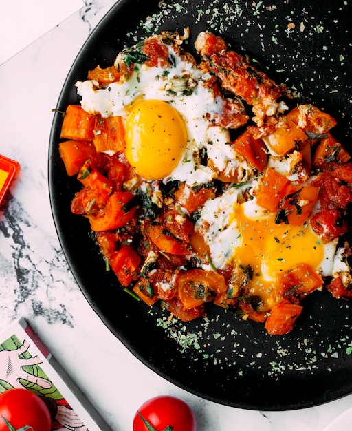 Verduras con hierbas y huevos fritos.