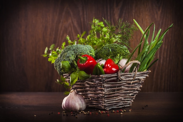 Verduras y hierbas saludables en canasta de mimbre