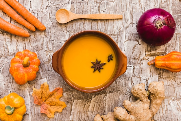 Verduras y hojas alrededor de sopa y cuchara