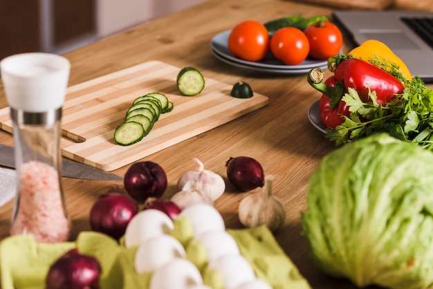 Verduras con huevos crudos y especias en la mesa