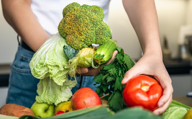 Verduras en manos femeninas el concepto de preparación de alimentos en la cocina