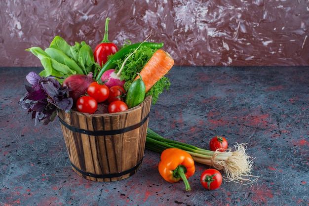 Foto gratuita verduras mixtas en un balde, sobre el fondo de mármol.