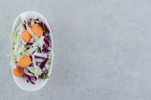 Verduras mixtas en un tazón, sobre el fondo de mármol.